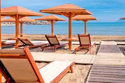 a group of chairs and umbrellas on a beach at On the Beach in Kissamos