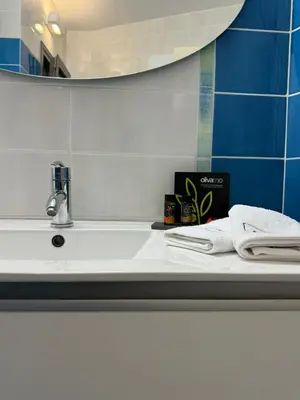 a bathroom with a sink with a mirror and towels at Seaty Luxury apartment in Chania Town