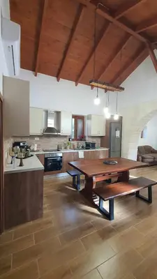 a large kitchen with a wooden table in a room at Villa Anasa Residence in Varípetron
