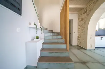 a staircase in a house with a stone wall at NAFSIKA XENIA-VILLA ARGO in Plátanos