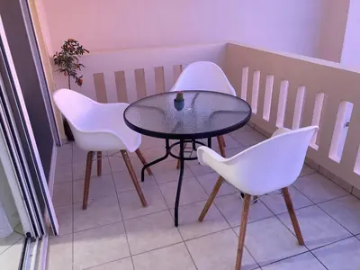 a table and two white chairs on a balcony at Stephanie's Place - Charming Apartment with Sea View in Chania Town