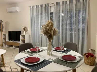 a dining room table with a vase of flowers on it at Stephanie's Place - Charming Apartment with Sea View in Chania Town