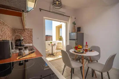 a kitchen with a table and chairs in a room at Ammoutsiani 2 Cozy Apartment by 8essentially in Chania Town
