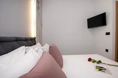 a bedroom with a bed with a couch and a television at ALPHA SUITES in Chania Town