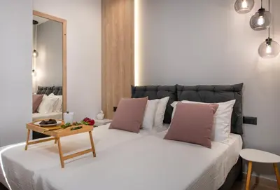 a bedroom with a large white bed with pink pillows at ALPHA SUITES in Chania Town