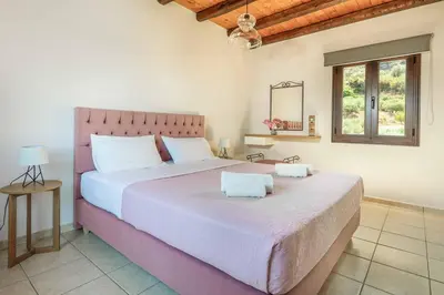 a bedroom with a large bed with a pink headboard at Villa Koule in Kalami