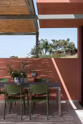 a patio with a table and chairs on a deck at Casa Tarrha- Beachfront Villa with Heated Pool in Livadia