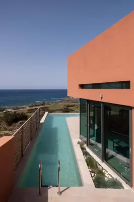 a house with a swimming pool next to the ocean at Casa Tarrha- Beachfront Villa with Heated Pool in Livadia