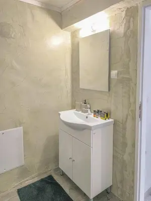 a bathroom with a white sink and a mirror at Comfy flat with large terrace, Fiber internet and private parking in Chania Town