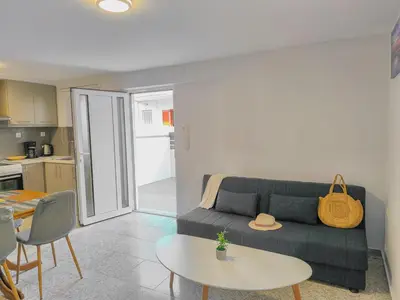 a living room with a couch and a table at Comfy flat with large terrace, Fiber internet and private parking in Chania Town