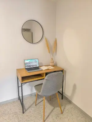 a desk with a laptop and a chair in a room at Comfy flat with large terrace, Fiber internet and private parking in Chania Town