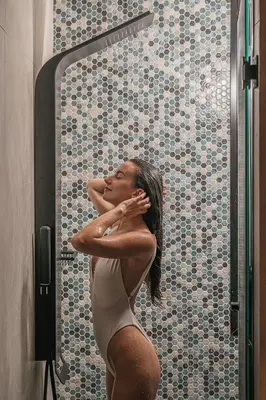 a woman standing in front of a bathroom mirror at Mimosa Minaret Jacuzzi Old Town Chania in Chania Town
