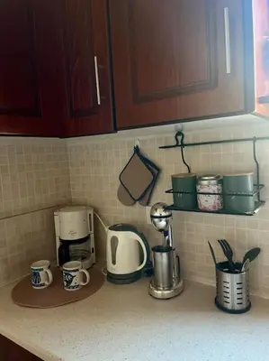 a kitchen counter with coffee makers and cups on it at Bayside Apt. in Souda