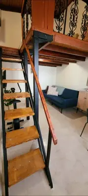 a wooden staircase in a room with a bunk bed at The Nook in Maleme