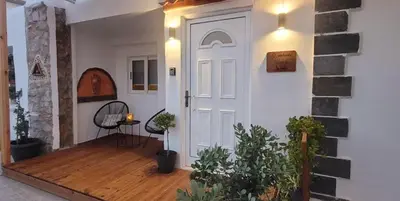 a white door in a room with a wooden floor at The Nook in Maleme