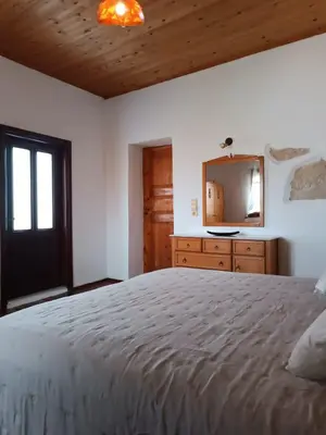 a bedroom with a large bed and a mirror at Villa Lina private pool in Kondomari