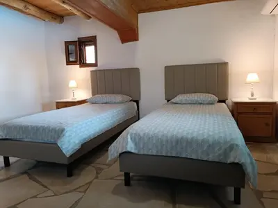 two beds in a room with white walls and wooden ceilings at Villa Lina private pool in Kondomari