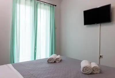 a bedroom with a bed with towels and a television at Kyril Apartment in Chania Town