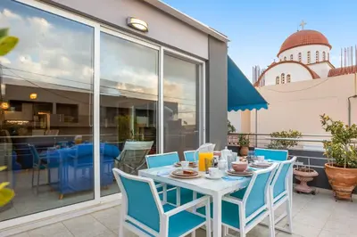 a white table with blue chairs on a patio at CasaParadiso in Perivólia