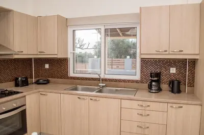 a kitchen with a sink and a window at Olivia House -BY APOKORNAS VILLAS in Káïna
