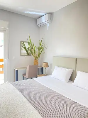 a bedroom with a white bed and a plant at NICOL's HOUSE in Chania Town
