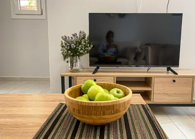 a bowl of green apples in a living room with a television at NICOL's HOUSE in Chania Town
