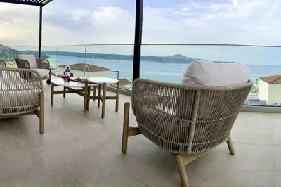 a balcony with chairs and a table and a view of the ocean at Luxury Sunset Villa with Private Pool & Sea Views in Kalyves