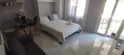 a bedroom with a bed and a table and windows at Cretan Dream in Chania Town
