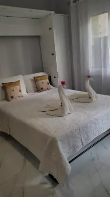 a white bed with two swans on it at Cretan Dream in Chania Town