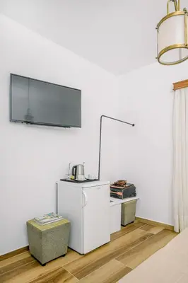 a room with a white wall with a tv on the wall at Kissamos Bay Hotel in Kissamos