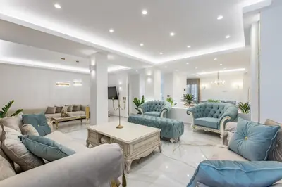 a living room with blue chairs and couches at Kallisti Palace - Private Pool with Hydromassage in Kissamos