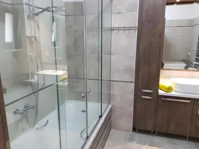 a bathroom with a glass shower and a sink at Angela Apartments in Kato Daratso