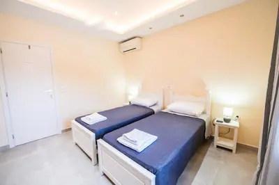 two beds in a small room with blue sheets at Aspro Apartments in Koprána