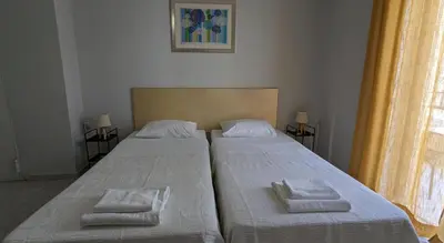 two beds in a room with two towels on them at Dimitris City Break Apts in Chania Town