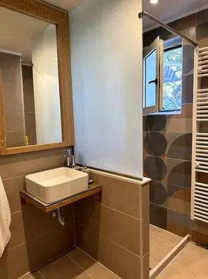 a bathroom with a sink and a mirror at Sunny flat among olive trees, next to the beach in Módhion