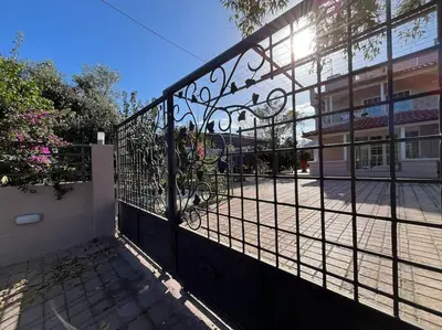 a metal fence with a gate in front of a building at Primavera Retreat in Chania Town