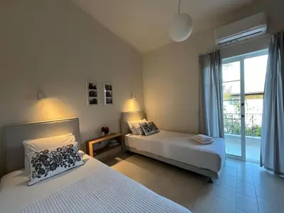 a bedroom with two beds and a large window at Verano Retreat in Chania Town