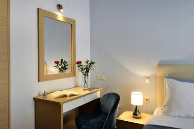 a bedroom with a desk with a mirror and a chair at Cosy apartment near the beach in Chania Town