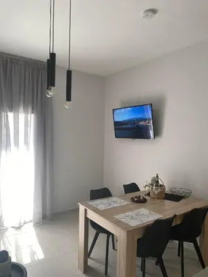 a dining room table with chairs and a tv on the wall at Kidonias apartment in Chania Town