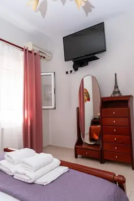 a bedroom with a tv and a bed and a mirror at Bella Vista Casa in Chania Town