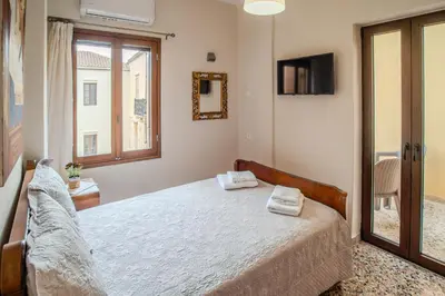 a bedroom with a bed and a tv and a window at In Heart of Old Town w. Venetian Port Views in Chania Town