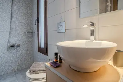 a bathroom with a white sink and a toilet at In Heart of Old Town w. Venetian Port Views in Chania Town