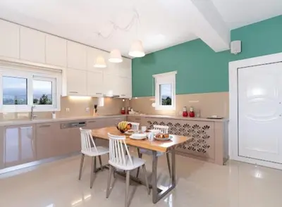 a large kitchen with a wooden table and chairs at Olive Grove Apartment in Chania Town