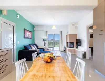 a kitchen and living room with a wooden table with a bowl of fruit at Olive Grove Apartment in Chania Town