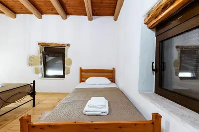 a small bedroom with a bed and a tv at Xanthippi's in Pemónia