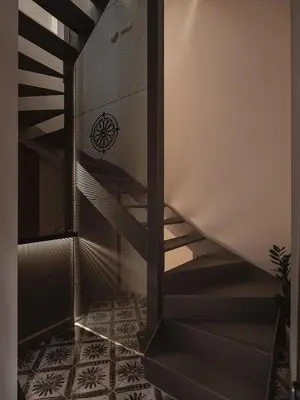 a staircase in a building with a wheel on the wall at Copal Simple Staying in Chania Town