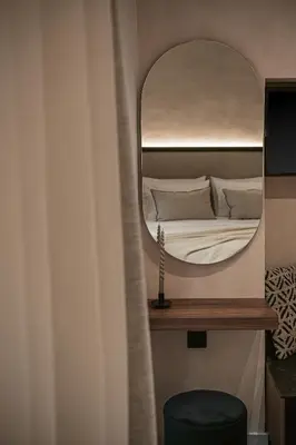 a bedroom with a large mirror and a bed at Copal Simple Staying in Chania Town