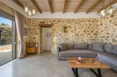 a living room with a couch and a table at Villa Eleftheria in Áyios Yeóryios