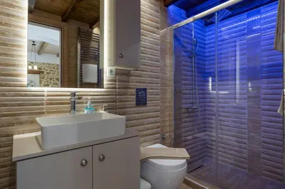 a bathroom with a toilet and a sink and a shower at Villa Eleftheria in Áyios Yeóryios