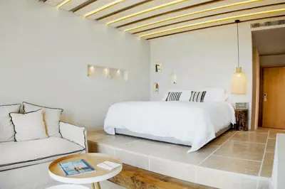 a white bedroom with a bed and a couch at The Theodore Boutique Hotel- adults only 16 plus in Agia Marina Nea Kydonias